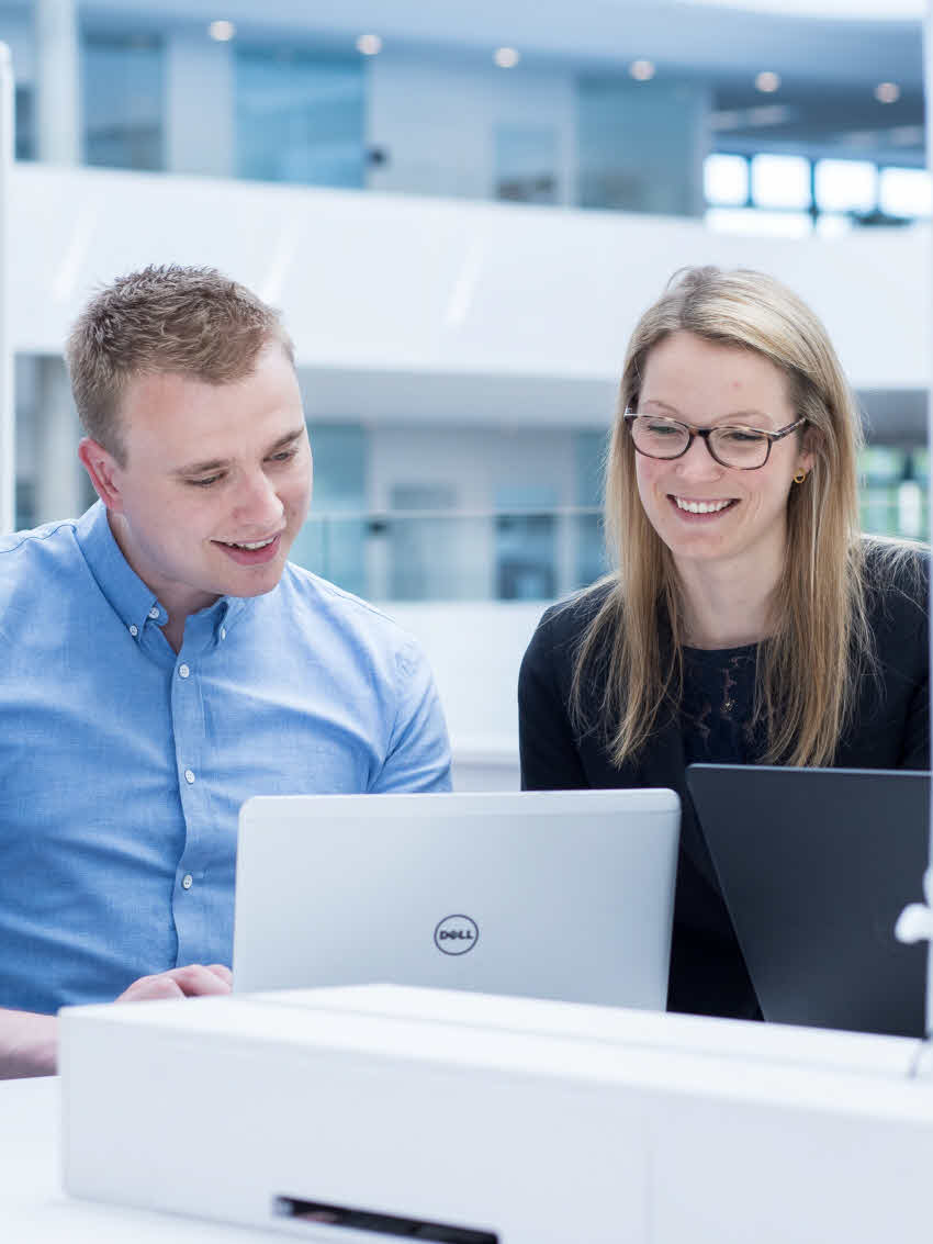 两名 DSV 员工一男一女在办公室看着电脑屏幕